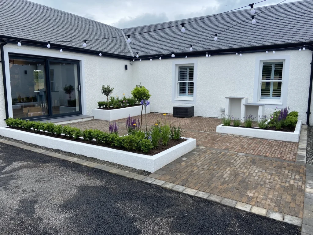 Garden Room Office in Ayrshire: Comfortable All Year Round 1 Courtyard garden with block paving, raised planters and sliding glazed doors at a whitewashed Ayrshire cottage
